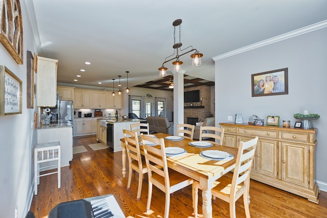 dining area featuring a fireplace, wood-type flooring, and crown molding