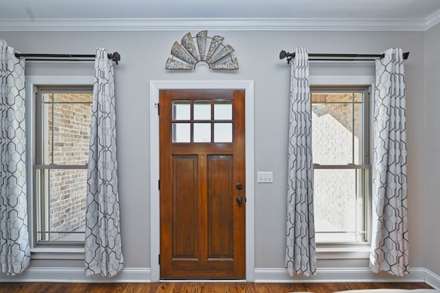 entrance foyer featuring crown molding, plenty of natural light, and hardwood / wood-style floors