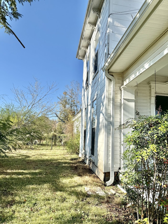 view of side of home with a lawn