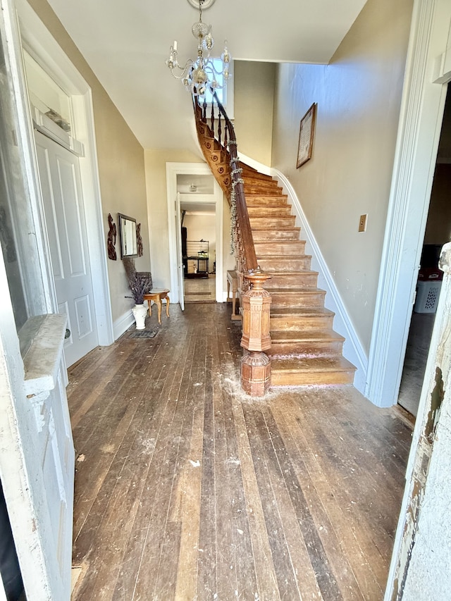 foyer entrance featuring dark hardwood / wood-style floors and a notable chandelier