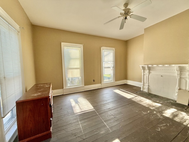 unfurnished living room with ceiling fan and dark hardwood / wood-style flooring