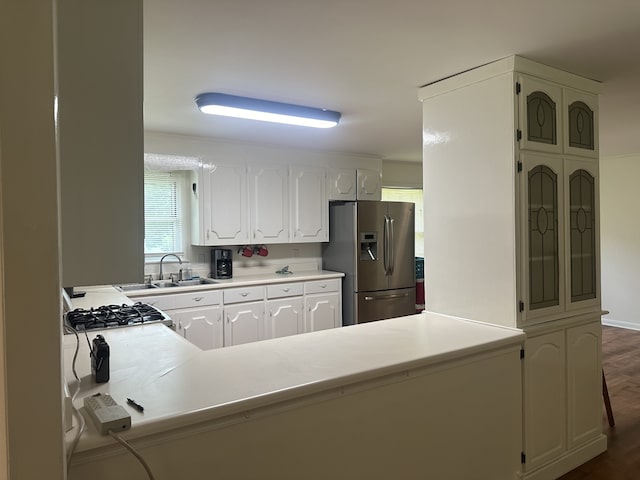 kitchen featuring white cabinets, sink, gas stovetop, dark hardwood / wood-style flooring, and stainless steel fridge with ice dispenser