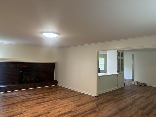 interior space with dark hardwood / wood-style flooring, a wood stove, and ornamental molding