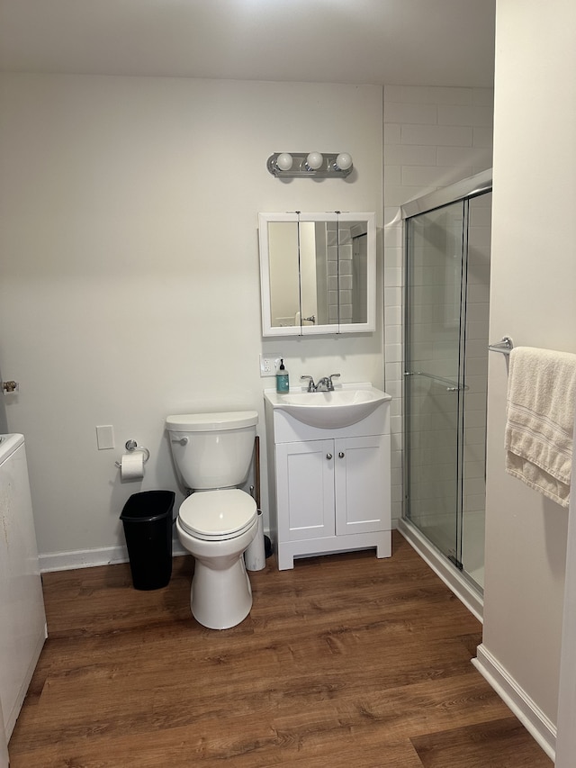 bathroom with vanity, wood-type flooring, a shower with shower door, and toilet