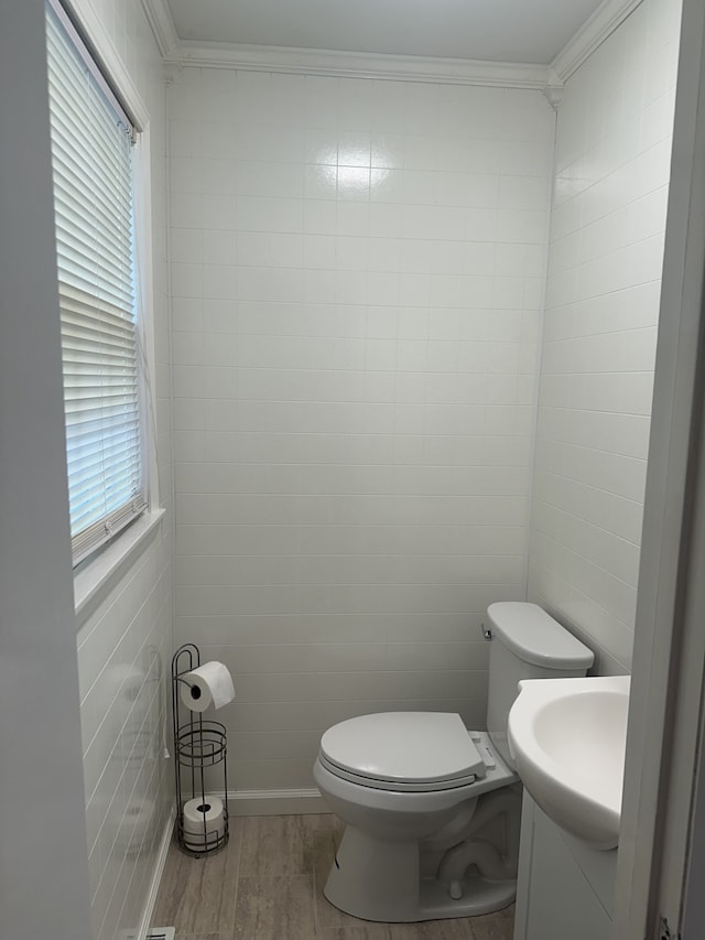 bathroom featuring hardwood / wood-style floors, toilet, plenty of natural light, and crown molding