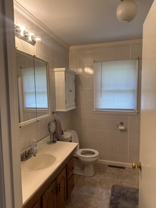 bathroom with crown molding, vanity, tile walls, and toilet