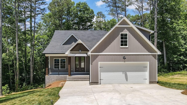 view of front facade with a front yard, a porch, and a garage