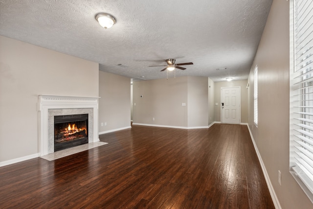 unfurnished living room featuring a textured ceiling, a premium fireplace, and dark hardwood / wood-style floors