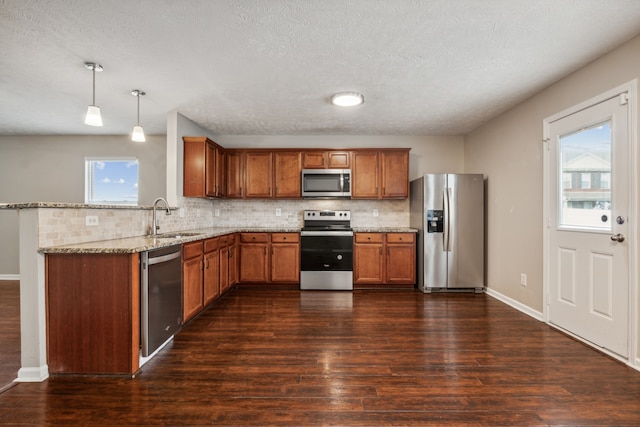 kitchen featuring decorative light fixtures, a healthy amount of sunlight, sink, and stainless steel appliances