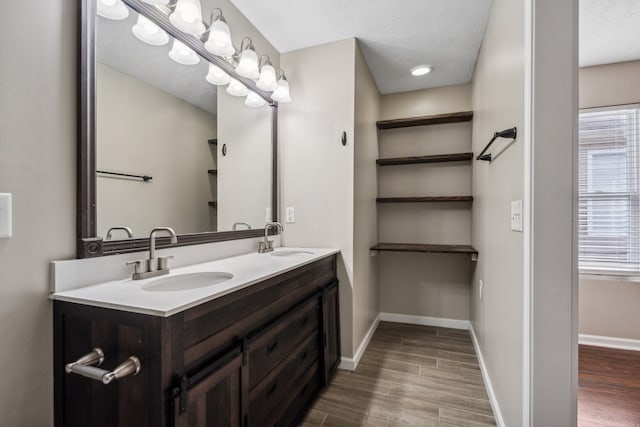 bathroom featuring hardwood / wood-style flooring, vanity, and a textured ceiling