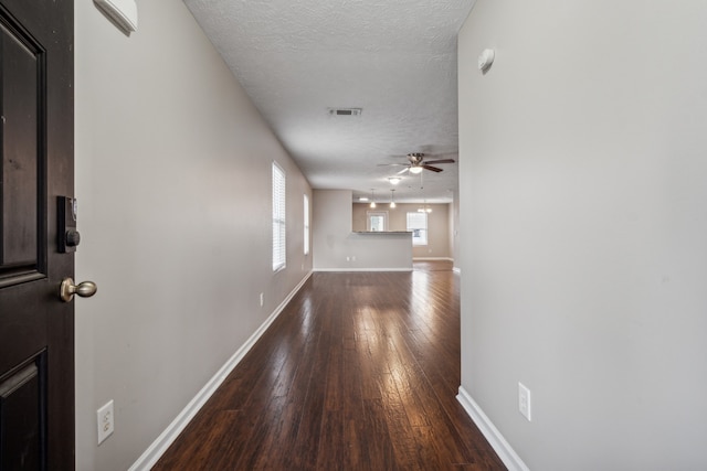 hall featuring wood-type flooring and a textured ceiling