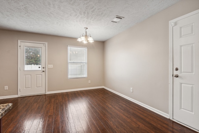 interior space featuring a notable chandelier, dark hardwood / wood-style flooring, and a textured ceiling