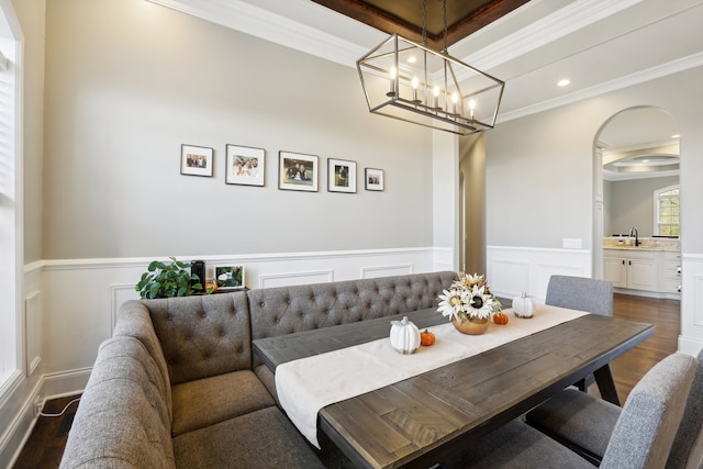 dining space featuring dark hardwood / wood-style flooring, ornamental molding, and sink