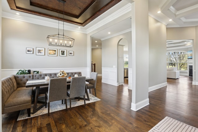 dining area featuring a chandelier, dark hardwood / wood-style floors, a raised ceiling, and crown molding