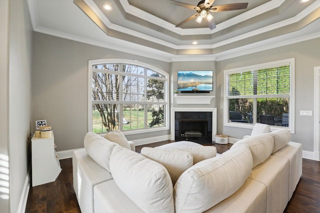 living room featuring dark hardwood / wood-style floors, a healthy amount of sunlight, ornamental molding, and ceiling fan