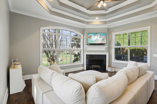 living room with a wealth of natural light, crown molding, ceiling fan, and dark wood-type flooring