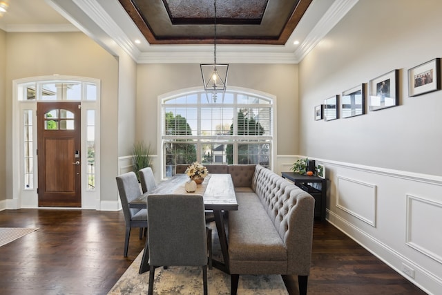 dining area featuring dark hardwood / wood-style floors, a raised ceiling, and crown molding