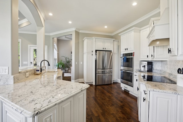 kitchen with backsplash, light stone countertops, dark hardwood / wood-style flooring, white cabinetry, and stainless steel appliances