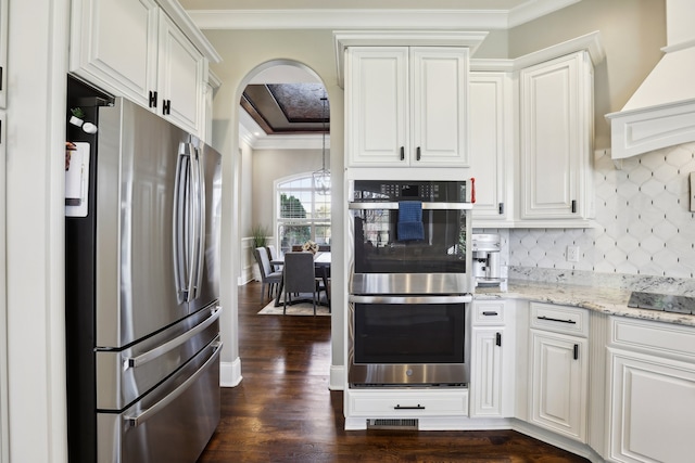 kitchen featuring dark hardwood / wood-style flooring, custom range hood, stainless steel appliances, crown molding, and white cabinetry