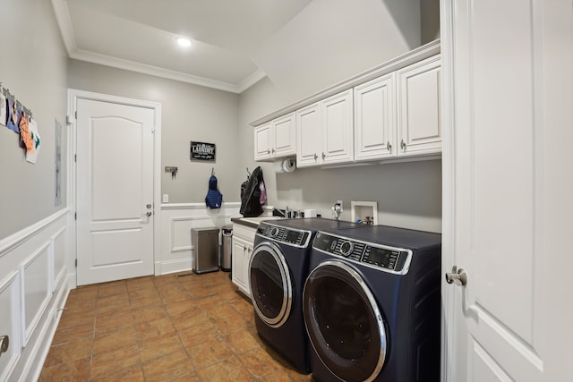 clothes washing area with washing machine and clothes dryer, crown molding, sink, and cabinets