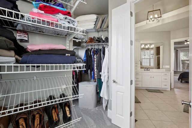 spacious closet with light tile patterned floors and sink