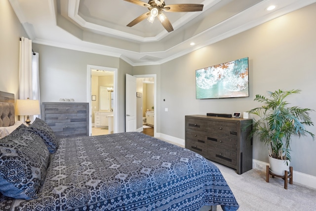 carpeted bedroom featuring ceiling fan, crown molding, connected bathroom, and a tray ceiling