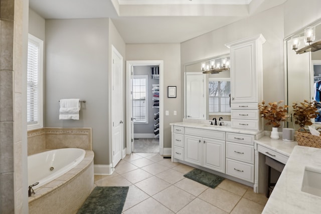 bathroom featuring tile patterned floors, plenty of natural light, vanity, and tiled bath