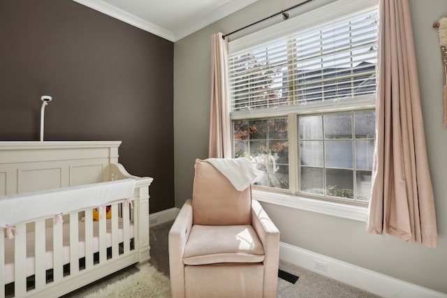 bedroom featuring light colored carpet, a nursery area, and ornamental molding