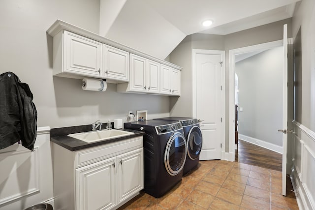 laundry area with light hardwood / wood-style flooring, cabinets, sink, and washing machine and clothes dryer