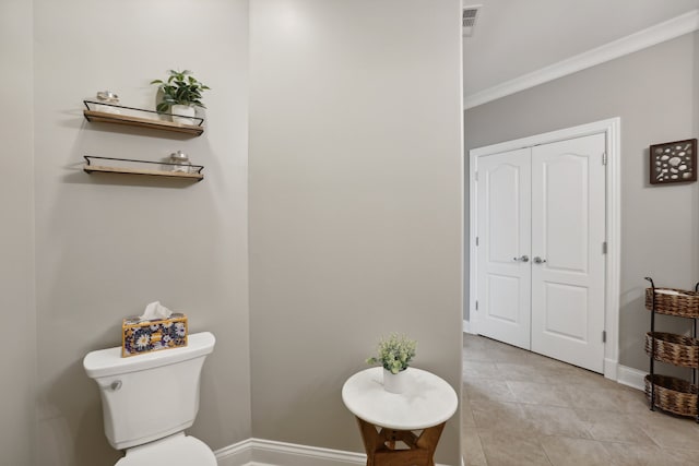 bathroom with tile patterned floors, toilet, and ornamental molding