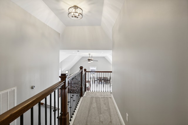 hall with carpet flooring, lofted ceiling, and a notable chandelier