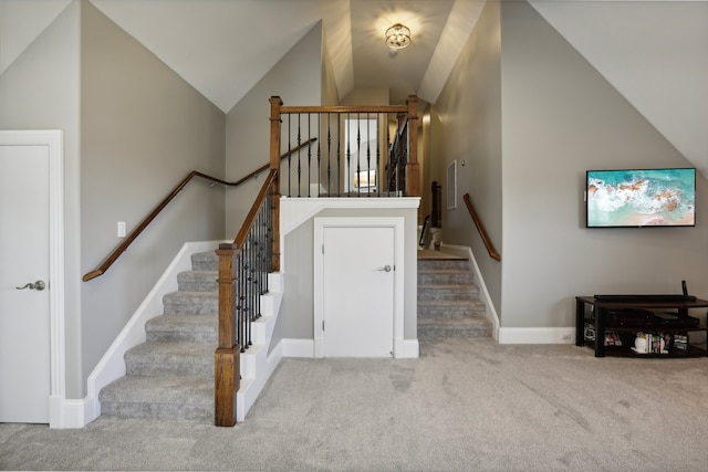 stairway featuring carpet and vaulted ceiling