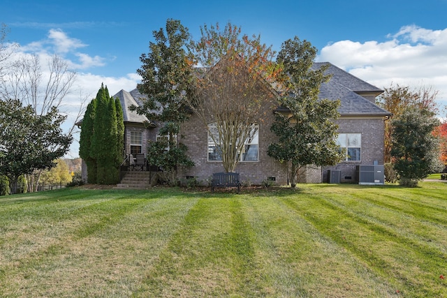 view of front of house with a front lawn and central AC unit