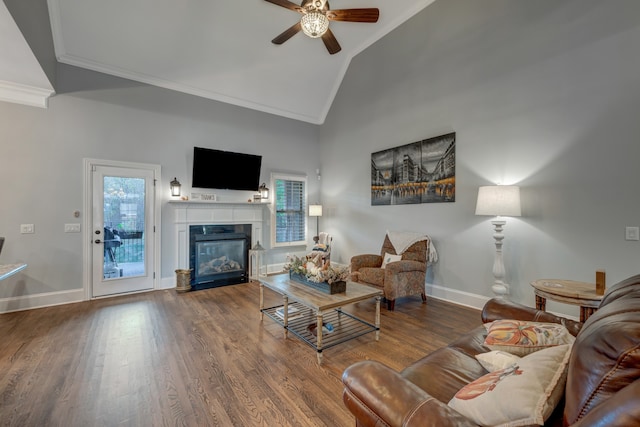 living room with ceiling fan, wood-type flooring, ornamental molding, and high vaulted ceiling