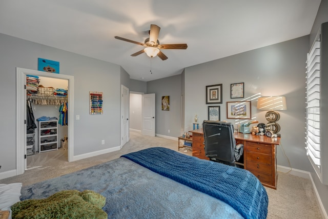 bedroom featuring light carpet, a spacious closet, a closet, and ceiling fan