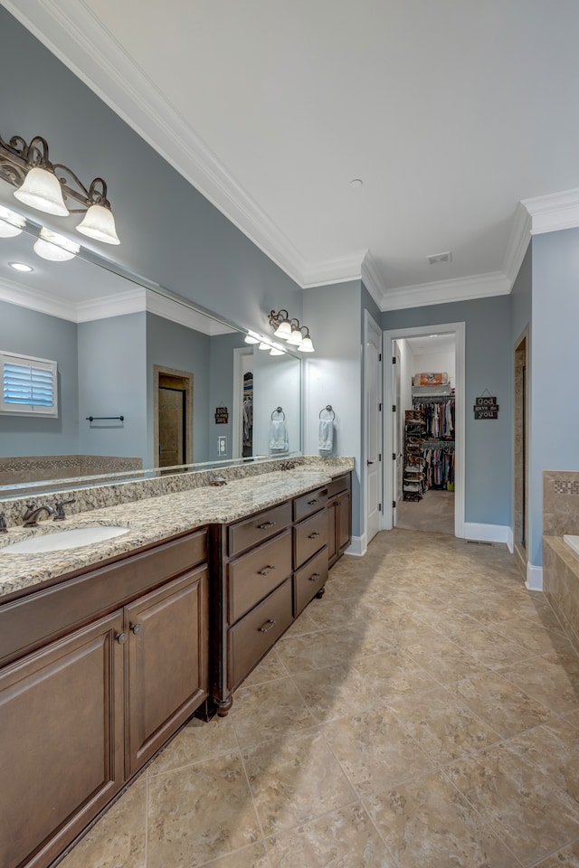 bathroom with crown molding, a washtub, and vanity