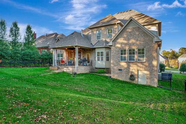 rear view of property featuring a patio and a lawn