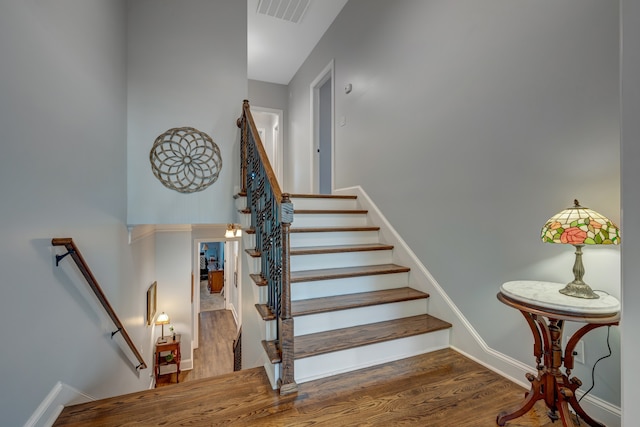 staircase with hardwood / wood-style flooring