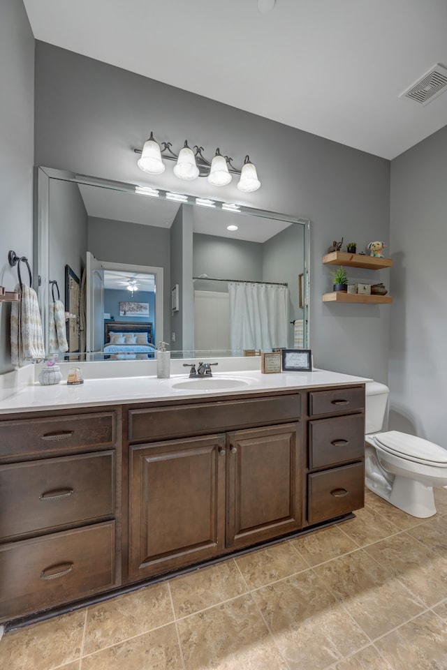 bathroom with tile patterned flooring, vanity, toilet, and walk in shower