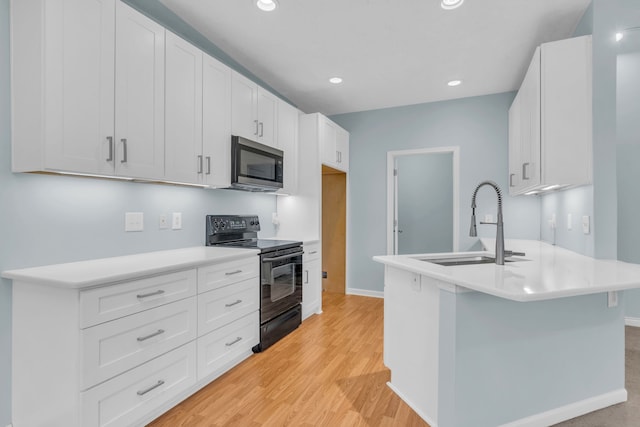 kitchen featuring white cabinets, black range with electric cooktop, and light hardwood / wood-style flooring