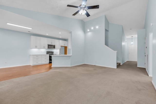 unfurnished living room featuring light hardwood / wood-style flooring, ceiling fan, and sink