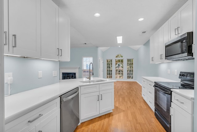 kitchen featuring white cabinetry, sink, light wood-type flooring, and appliances with stainless steel finishes