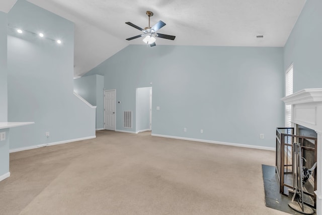 carpeted living room with ceiling fan and vaulted ceiling