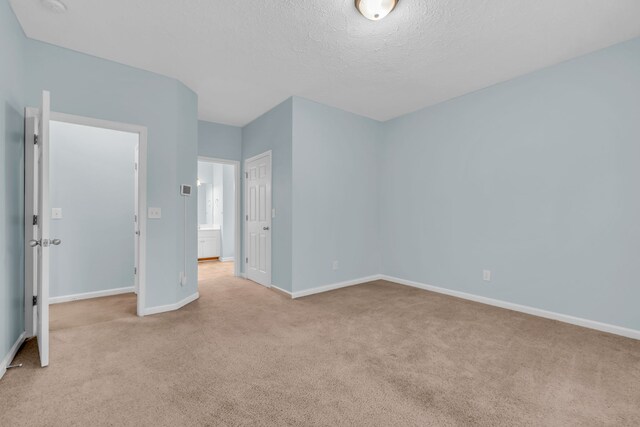 unfurnished room featuring light colored carpet and a textured ceiling