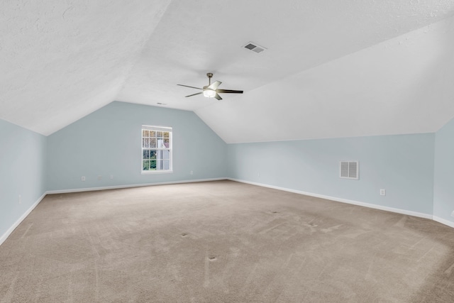 bonus room with light carpet, a textured ceiling, ceiling fan, and lofted ceiling