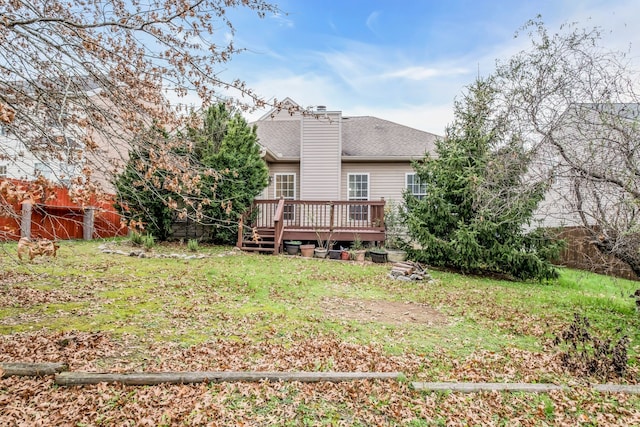 rear view of property featuring a deck and a yard