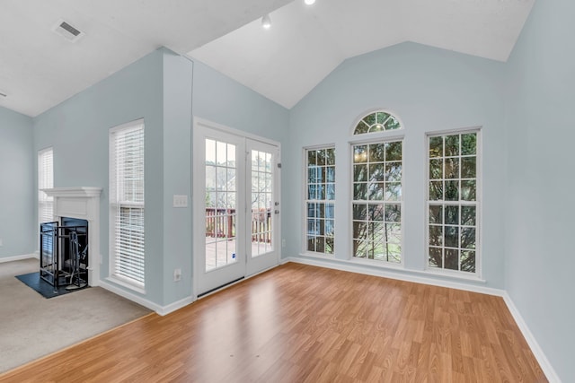 doorway to outside with light hardwood / wood-style flooring and lofted ceiling