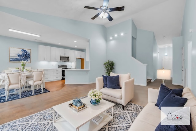 living room with ceiling fan and light hardwood / wood-style floors