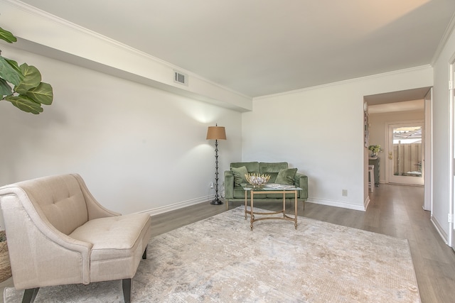 sitting room with hardwood / wood-style floors and ornamental molding