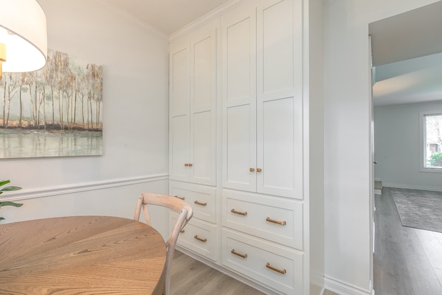 dining area featuring light wood-type flooring and ornamental molding